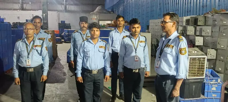 VSS guards in blue uniforms during a briefing inside a warehouse